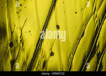 Abstract yellow fluid background featuring dark bubbles, organic patterns, and textured wavy lines, creating a unique liquid design Stock Photo
