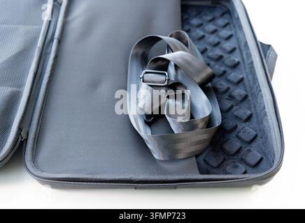 An open black equipment case contains a folded strap Stock Photo