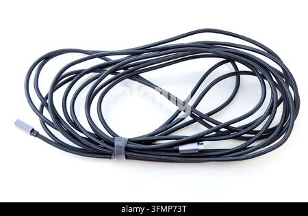 A long braided charging cord rests coiled on white background Stock Photo