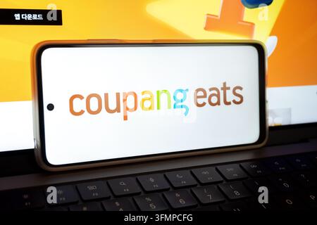 Mexico city, mexico, 06 20 2026, smartphone displaying coupang eats logo on laptop keyboard Stock Photo