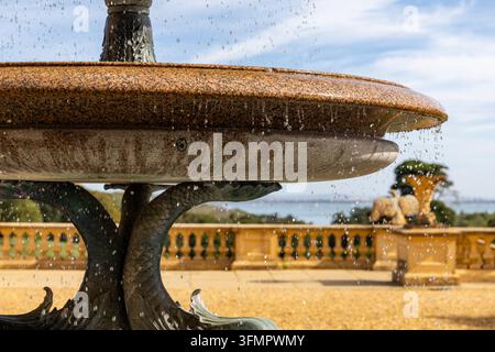 Close-up of an ornate stone fountain basin with falling water droplets in a sunlit formal garden Osborne House Isle of Wight Stock Photo