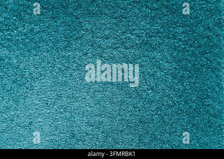Macro photograph of a vibrant teal suede leather surface displaying a fine velvety texture and subtle directional lighting. Stock Photo