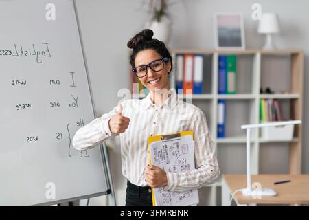 Happy Middle Eastern Woman Educator Giving Thumbs Up In Office, Business Concept Stock Photo