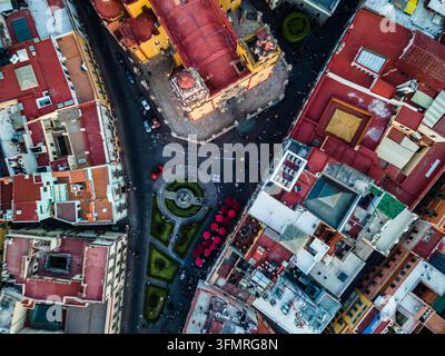 Top-down drone shot of red rooftops and historic cathedral plaza in the center of Guanajuato. Stock Photo