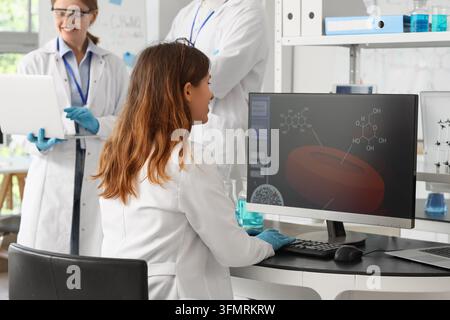 Medical research and pharmaceutical development, scientists analyzing molecular structures on computer in laboratory with team collaboration and data Stock Photo