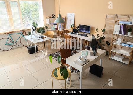 Remote work and coworking space, modern office interior with multiple desks for freelancers and digital nomads in a bright open plan workspace Stock Photo
