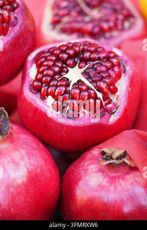 Fresh pomegranates displayed on a table at a market in autumn season Stock Photo