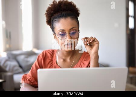 Close up of focused African woman working on laptop Stock Photo