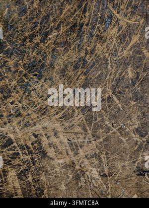 Close-up of rough wall surface with beige scratches over dark navy patches, creating layered grunge texture. Irregular scuffs, worn plaster, and earth Stock Photo