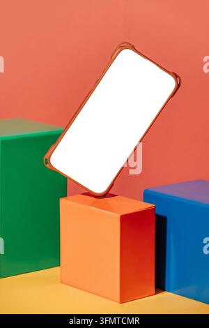 A smartphone with a blank white display floats above colorful geometric cubes against an orange background, creating a modern 3D mockup for mobile app Stock Photo