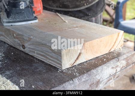 Electric Planer on Wooden Boards Beside a Pile of Wood Shavings Stock Photo