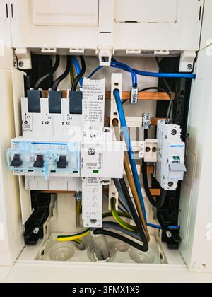 Electrical distribution panel with surge protection, circuit breakers and color-coded wiring installed for a residential heating system. Stock Photo