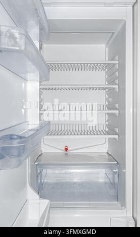 An empty refrigerator showing clean shelves and door racks inside. Stock Photo
