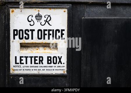 Llanfyllin, Wales, UK -September 7, 2026; Ludlow style wall box with King George VI royal cypher on post office letter box Stock Photo