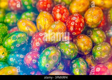 Colorful Easter Chocolate Eggs Wrapped in Shiny Foil with Floral Patterns Stock Photo