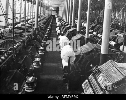 Carding machines that disentangle, clean and intermix fibres to produce a continuous web or sliver in cotton mills/ or spinning-mills. Victorian factory mechanised wool spinning looms. Carding engines. Stock Photo