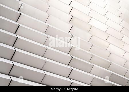 Abstract close-up of a contemporary architectural facade featuring layered white panels, precise structural design, and repeating geometric lines in a Stock Photo