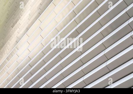 Abstract view of a contemporary architectural ceiling with repeating curved white ribs, geometric lines, and soft shadows creating a refined modern st Stock Photo