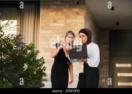 Business Colleagues Collaborating Outdoors With Laptop — Diverse Female Professionals Discussing Project Stock Photo