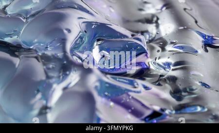 Abstract close-up of flowing metallic fluid with silver, blue, and violet reflections, creating a glossy futuristic technology background with liquid Stock Photo