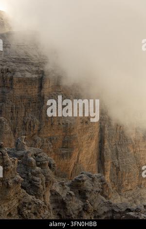 Dramatic limestone cliffs disappearing into low cloud in the Dolomites, Italian Alps, Italy. Stock Photo