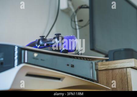 Balikpapan, Indonesia - September 9 2026. Close-up view of a purple video game controller placed on top of a modern white video game console, indoors Stock Photo
