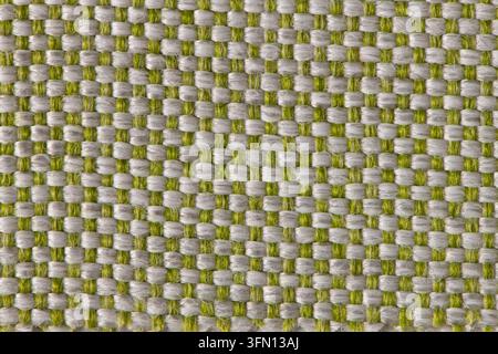 Macro shot of thick woven upholstery fabric featuring interwoven green and white threads, lit by soft directional light to emphasize its geometric gri Stock Photo