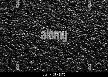 Abstract black shiny textured background of crushed plastic material. Dark texture background filled with small crumpled glossy black particles. Perfe Stock Photo