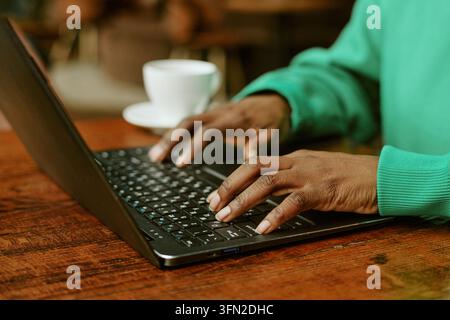 Hands of Black Woman Typing on Laptop Keyboard in Cafe Stock Photo