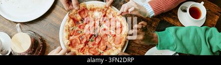 Header of Diverse Group of Friends Sharing Pepperoni Pizza in Cafe Stock Photo