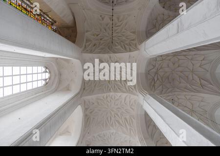 View of the intricate star-vaulted ceiling with white stone ribs and gold accents inside the historic St. Mary's Church in Gdansk, Pomeranian Voivodes Stock Photo
