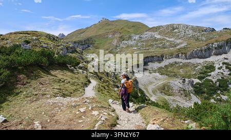 A hiker explores the serene trails of Schafler Ridge in Appenzell Switzerland, surrounded by stunning landscapes. The clear blue sky and lush greenery create a perfect setting for outdoor adventure. Stock Photo