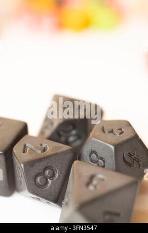 Vertical macro close up of black polyhedral role playing dice on white background Stock Photo
