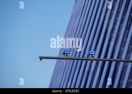 Security cameras mounted on pole with modern building background Stock Photo