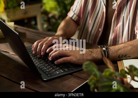 Hands of Man Typing on Laptop Keyboard Working Remotely Stock Photo