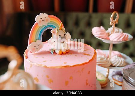 Pink unicorn birthday cake with rainbow decoration Stock Photo