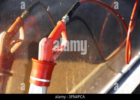 Car wash equipment with spray gun, hose at self service station, DIY vehicle cleaning, pressure washing, car care, maintenance concept. Stock Photo