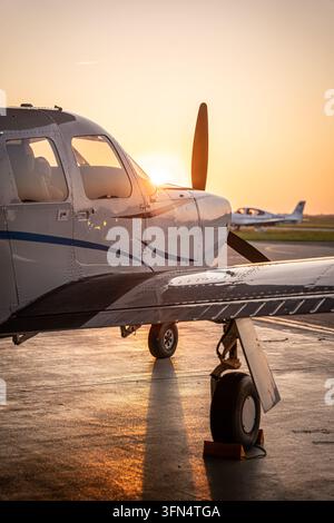View of a private airplane parked on the tarmac at Hannover Airport during golden hour in Langenhagen, Niedersachsen, Germany. Stock Photo