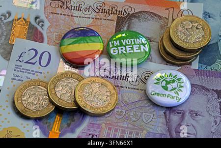 Green Party badges, rainbow badge and sterling banknotes illustrating UK political funding and campaigning. Stock Photo