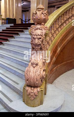 Buenos Aires, Argentina - July 30, 2017: Detailed view of ornate marble staircase balustrade, lion sculpture, and red carpet steps inside Teatro Colon Stock Photo
