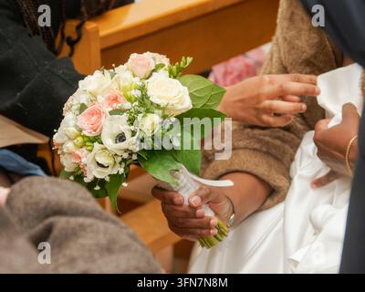 Close-up of wedding bouquet held by a person in a ceremony setting. Stock Photo