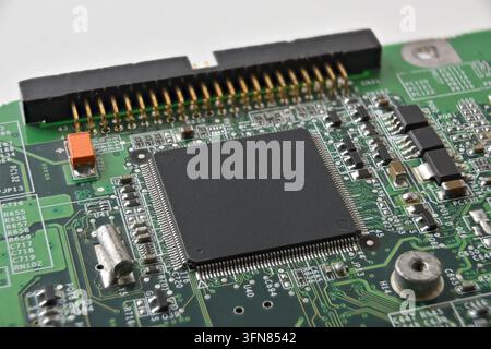 Detailed view of an embedded microcontroller on a green printed circuit board with connectors and surface-mounted components, illustrating industrial Stock Photo