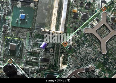 Detailed close-up of an old and damaged computer motherboard with worn and broken components. Represents obsolete technology, electronic waste, hardwa Stock Photo