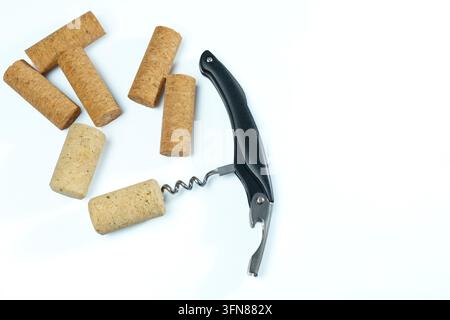 Corks and a corkscrew laying on a white surface, preparing for opening a wine bottle and enjoying a beverage Stock Photo