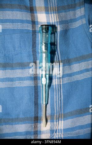 Close up of electronic voltage tester pen with screwdriver tip on plaid shirt pocket Stock Photo