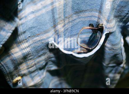 Close up of eyeglass inside plaid shirt pocket Stock Photo