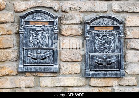 Ornate mailboxes for Marija and Miroslav Rajković are mounted on a rustic brick wall to collect their incoming mail, Patrijarha/ Patriarch  Rajacica s Stock Photo