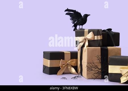 Halloween shopping and holiday sales, black and brown gift boxes with gold ribbons and raven decoration on a purple background for seasonal marketing Stock Photo