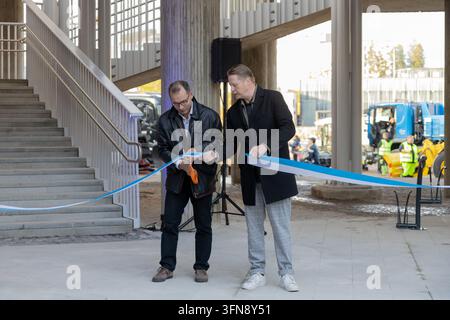 Espoo, Finland - October, 1st, 2026: Two men cutting a blue and white ceremonial ribbon during the opening event near the renovated Meritie street and Stock Photo