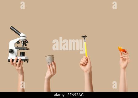Stem education and agricultural science diverse hands holding microscope seedling pot garden rake and orange peel for biology and nutrition research Stock Photo